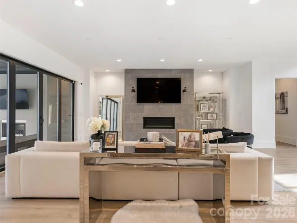 a living room with furniture a flat screen tv and a fireplace