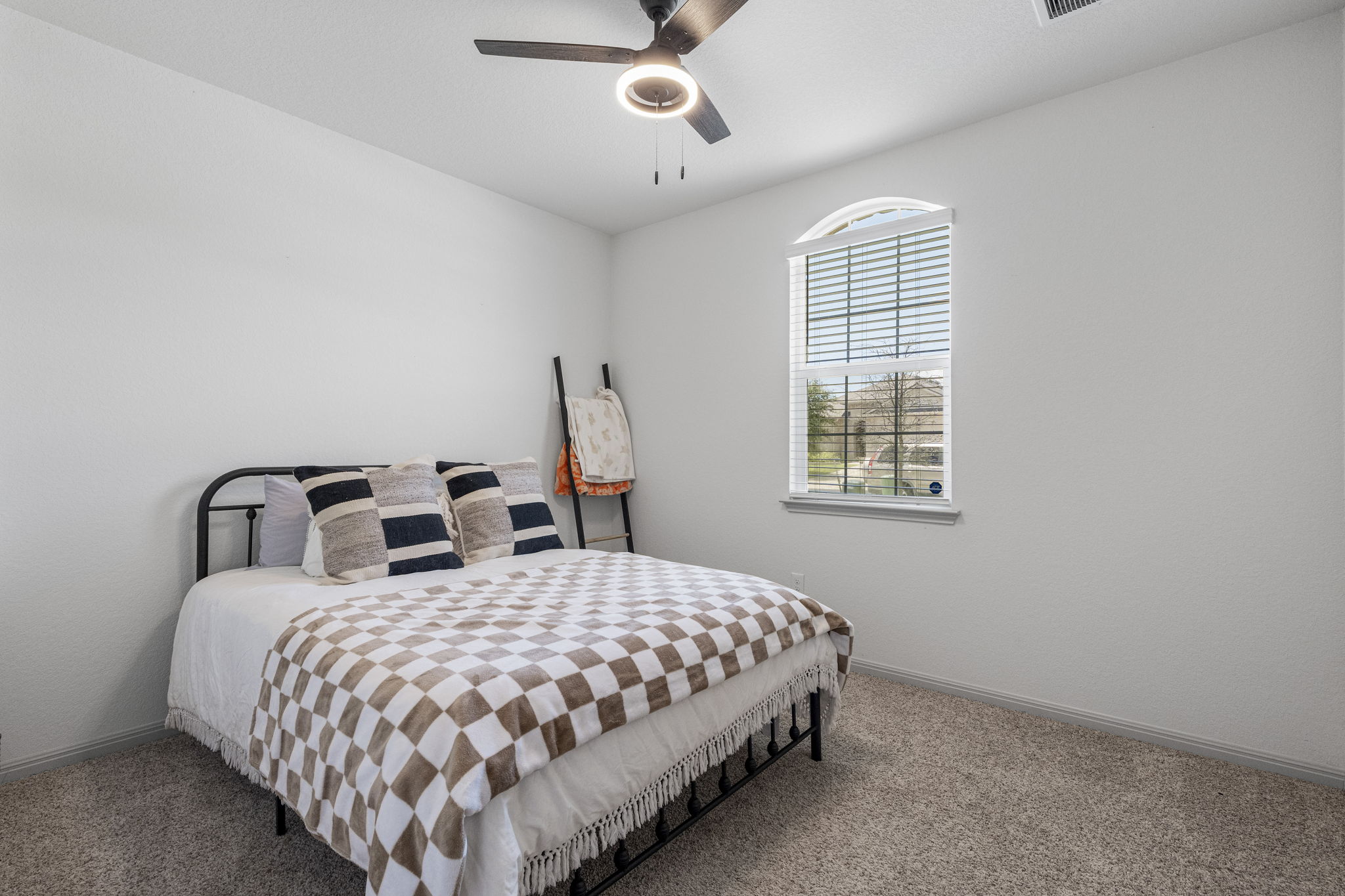 185 Struss Drive Georgetown, TX 78626 - Photo 16 of 23 A quiet bedroom with a charming arched window and a modern ceiling fan for comfort.