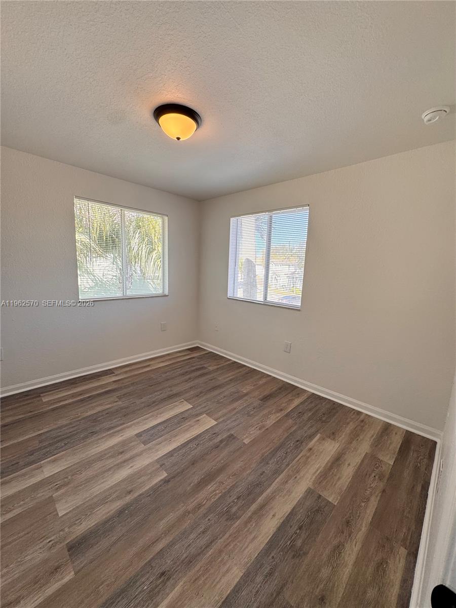 2732 Southeast 15th Place, Unit 142 Homestead, FL 33035 - Photo 11 of 20 a view of empty room with wooden floor and fan