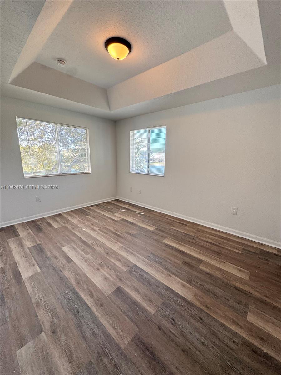 2732 Southeast 15th Place, Unit 142 Homestead, FL 33035 - Photo 17 of 20 an empty room with wooden floor and windows