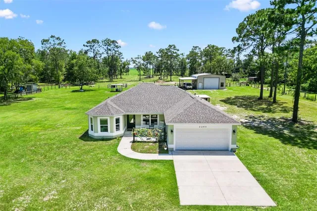 a aerial view of a house with swimming pool and a garden