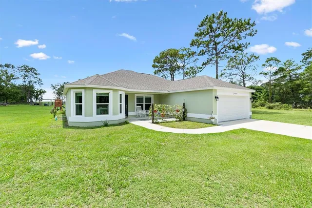 a view of a house with swimming pool and a yard