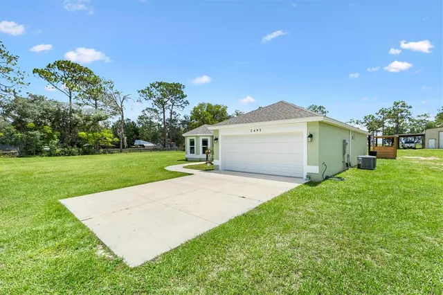 a view of a white house with a yard and garage