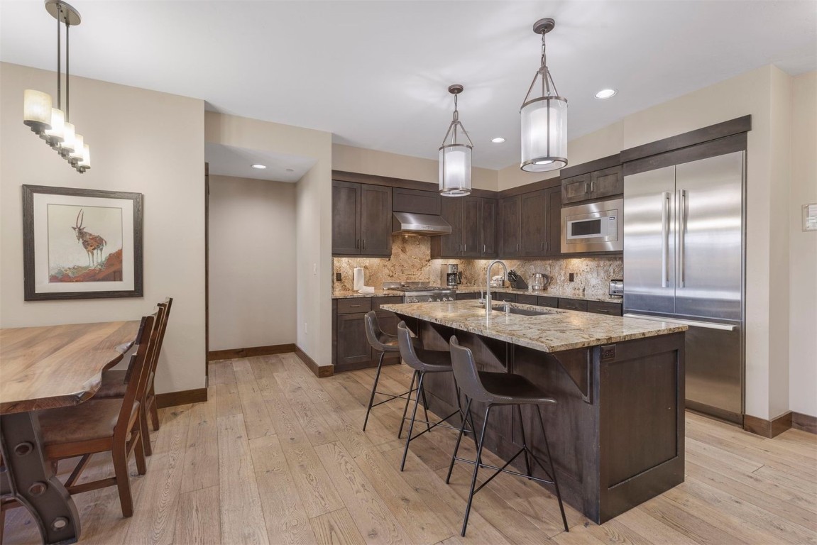 610 Columbine Road, Unit 6307 Breckenridge, CO 80424 - Photo 11 of 36 a kitchen with kitchen island a dining table and a chandelier
