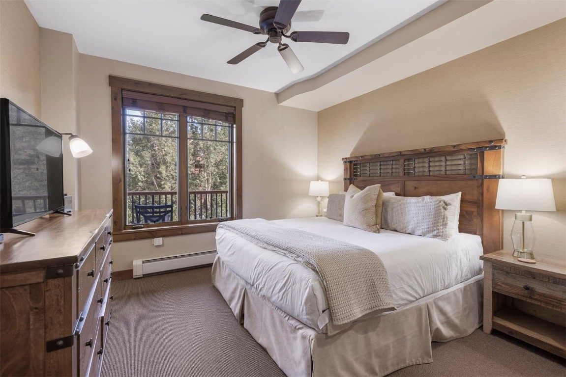 610 Columbine Road, Unit 6307 Breckenridge, CO 80424 - Photo 16 of 36 a bedroom with a large bed and a flat tv screen on a dresser