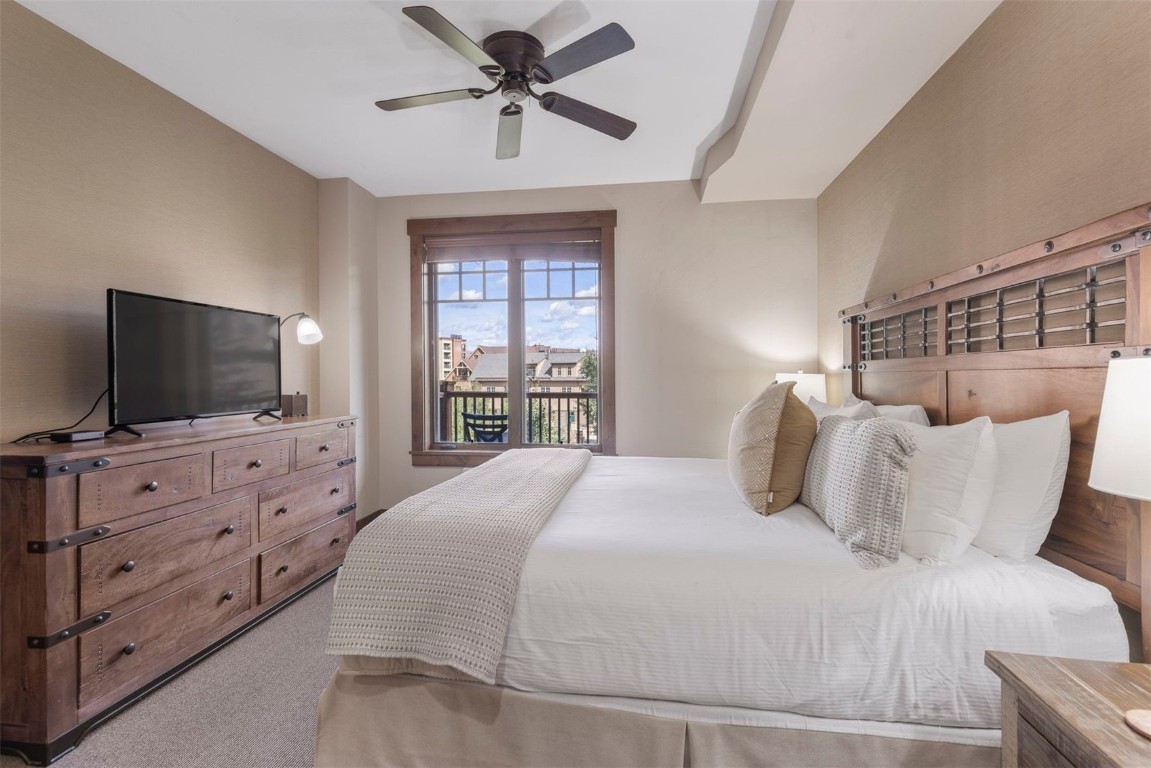 610 Columbine Road, Unit 6307 Breckenridge, CO 80424 - Photo 17 of 36 a bedroom with a large bed and a flat screen tv
