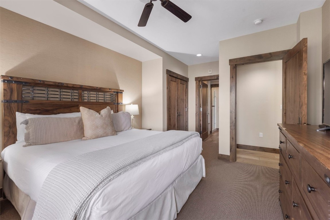 610 Columbine Road, Unit 6307 Breckenridge, CO 80424 - Photo 18 of 36 a bedroom with a bed and a chandelier