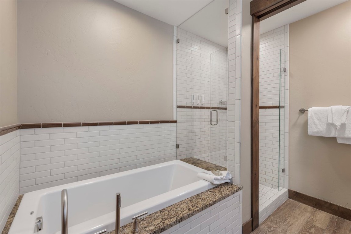 610 Columbine Road, Unit 6307 Breckenridge, CO 80424 - Photo 21 of 36 a bathroom with a granite countertop bathtub and shower
