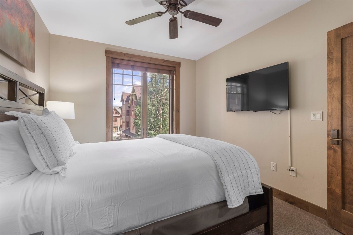 610 Columbine Road, Unit 6307 Breckenridge, CO 80424 - Photo 23 of 36 a bedroom with a bed and a flat screen tv