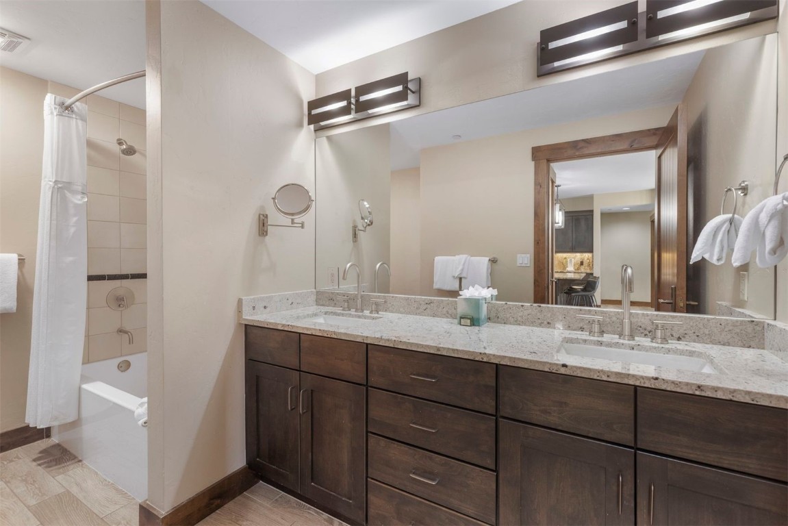 610 Columbine Road, Unit 6307 Breckenridge, CO 80424 - Photo 25 of 36 a bathroom with a granite countertop sink mirror and a shower