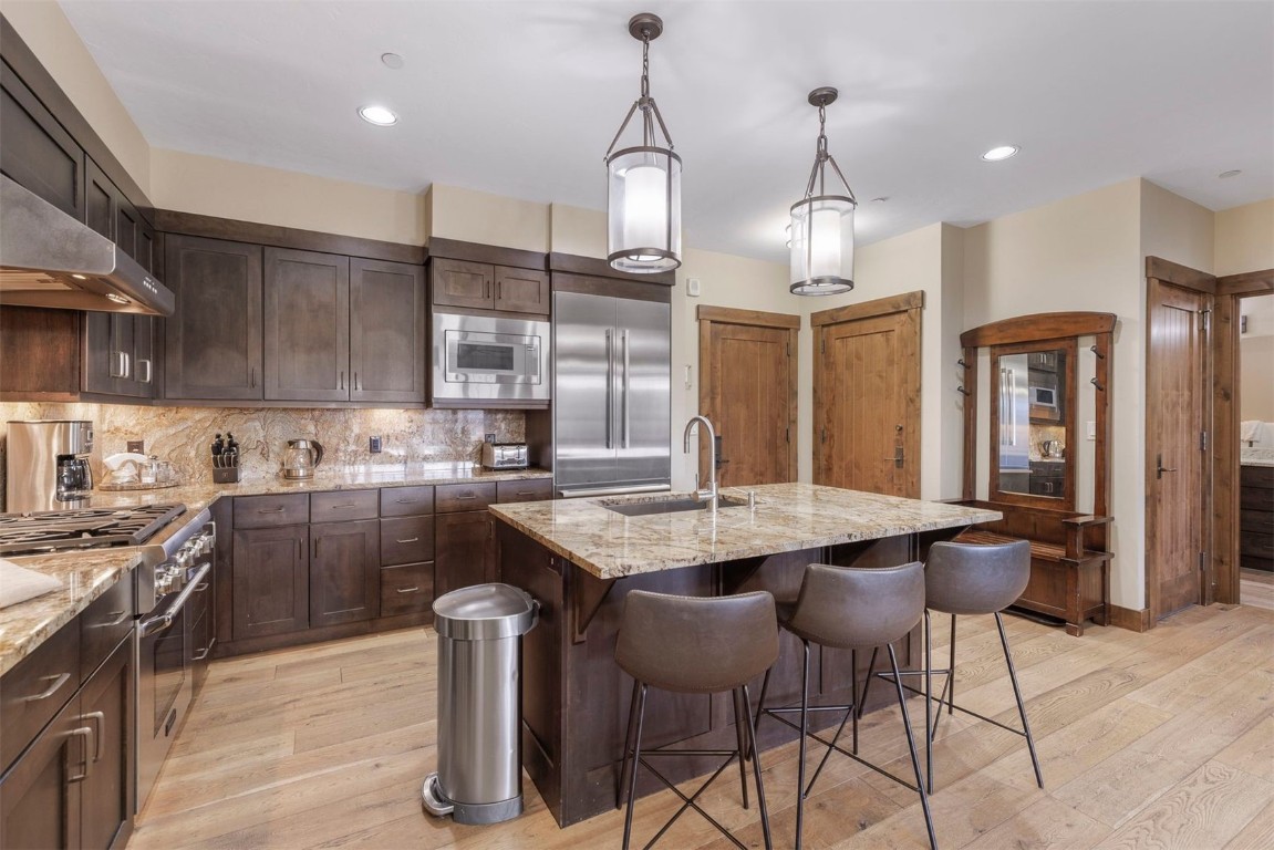 610 Columbine Road, Unit 6307 Breckenridge, CO 80424 - Photo 7 of 36 a kitchen with kitchen island granite countertop a sink a counter space appliances and cabinets