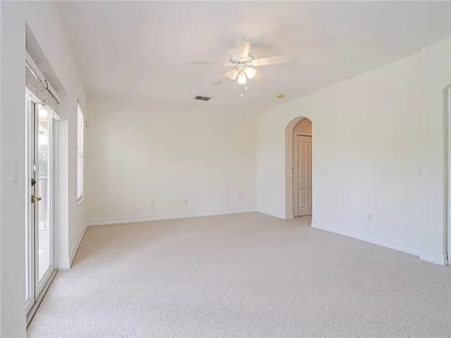 a view of an empty room with a chandelier fan