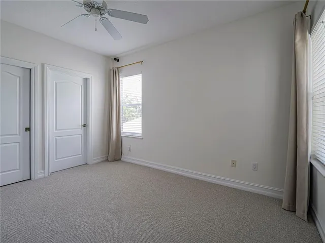 an empty room with a window and a fan