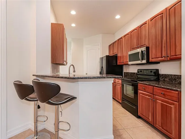 a kitchen with stainless steel appliances granite countertop a stove a sink and a microwave