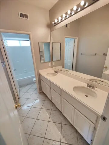 a spacious bathroom with a double vanity sink a mirror and a shower
