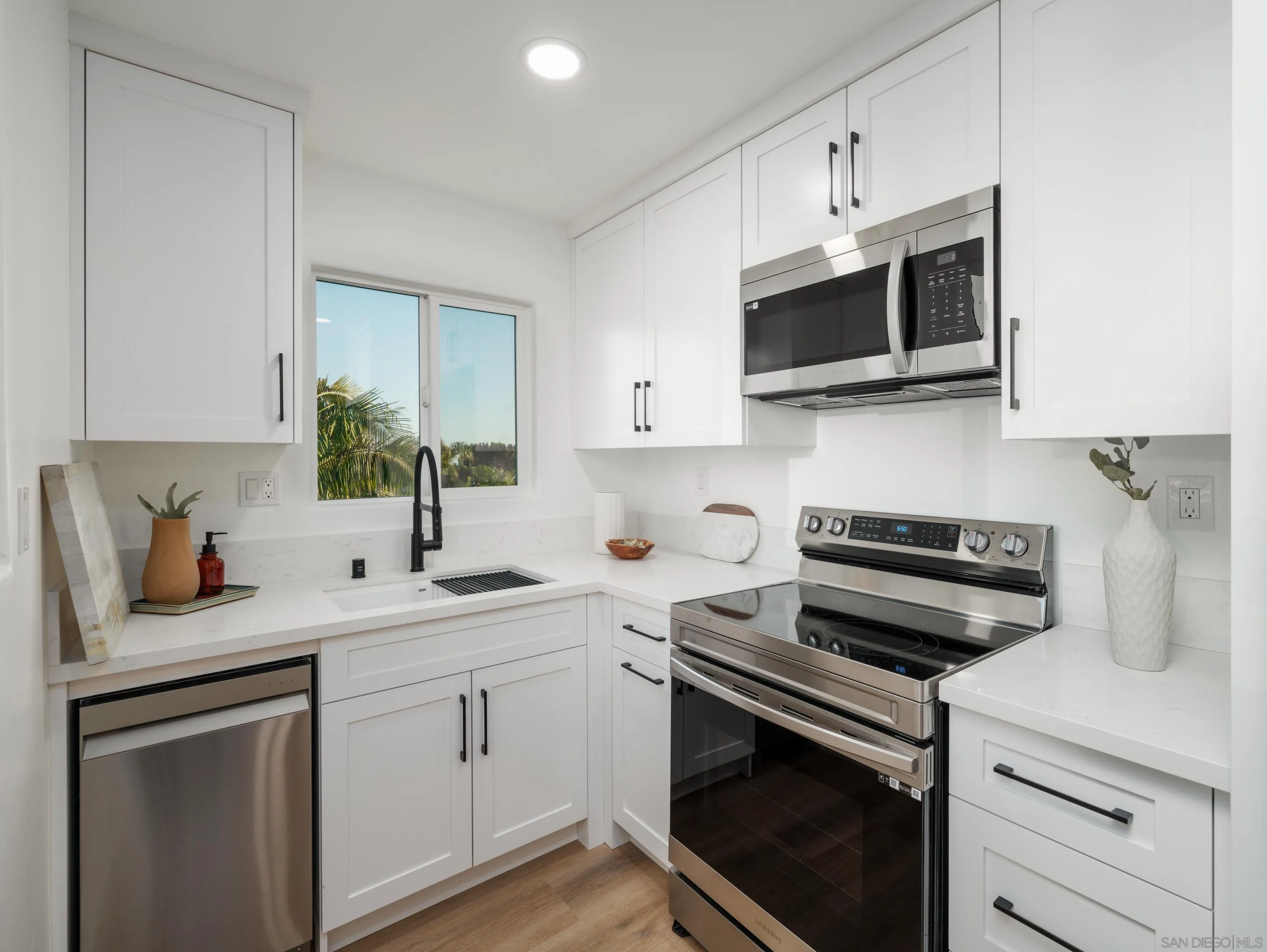 1868 Pariva Drive Cardiff, CA 92007 - Photo 24 of 30 a kitchen with stainless steel appliances white cabinets sink and stove