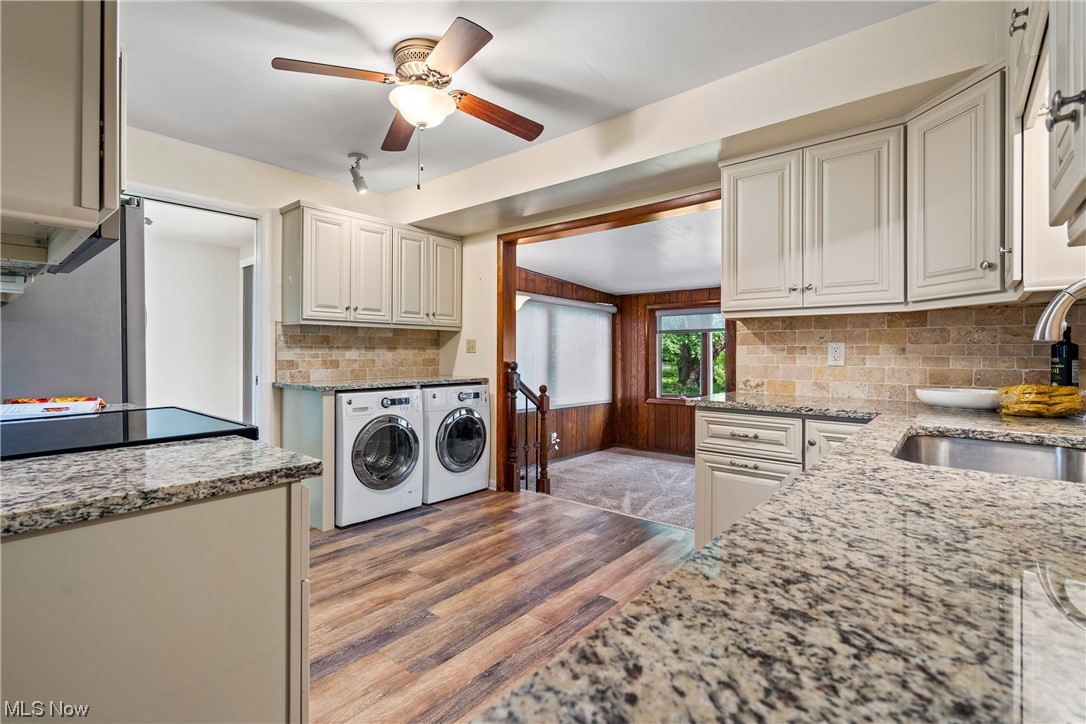 8899 Priem Road Strongsville, OH 44149 - Photo 11 of 35 Kitchen featuring sink, washer and dryer, ceiling fan, light hardwood look floors, and light stone counters