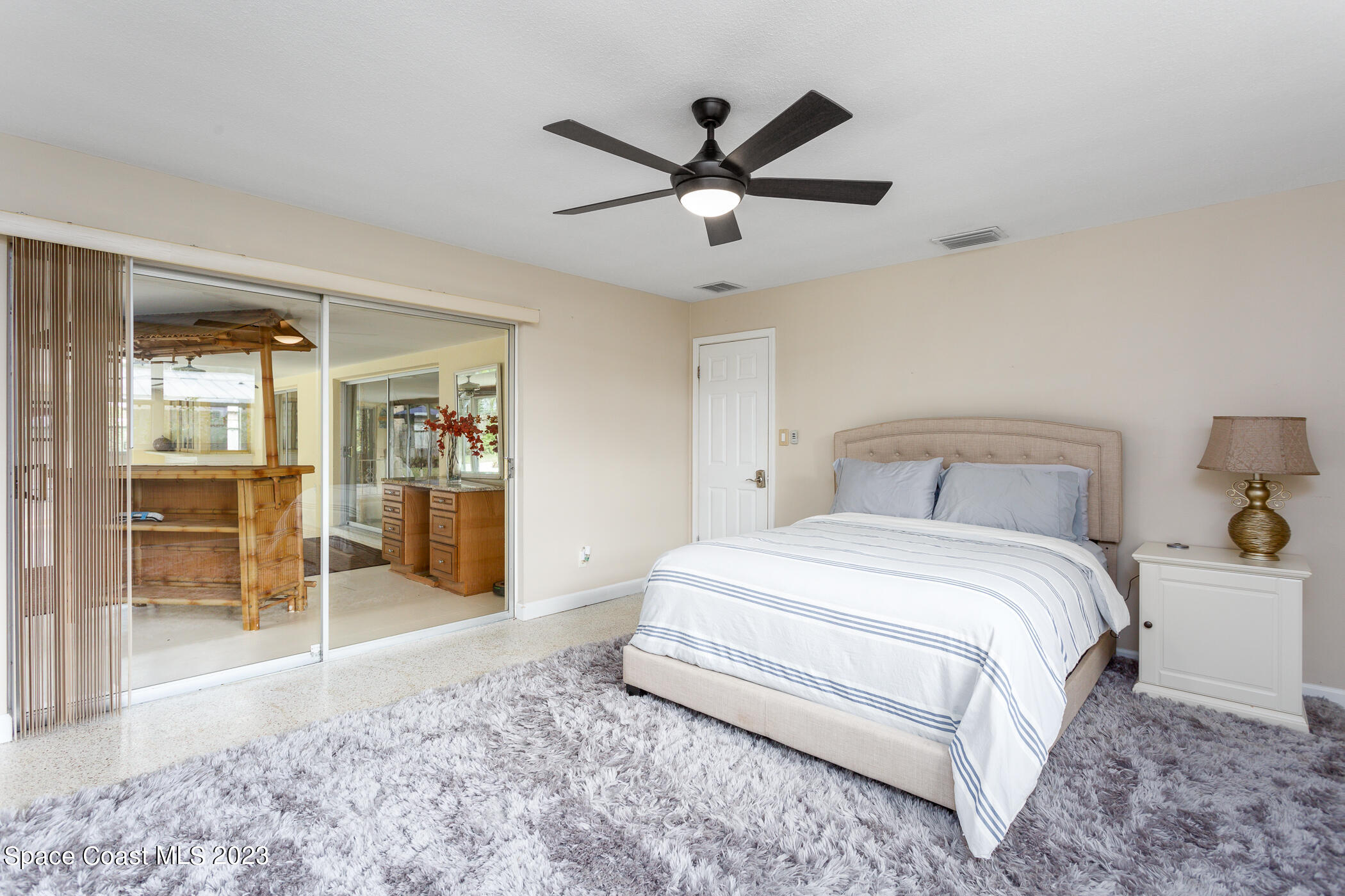 608 Mango Drive Melbourne Beach, FL 32951 - Photo 11 of 30 a spacious bedroom with a bed and a view of bathroom