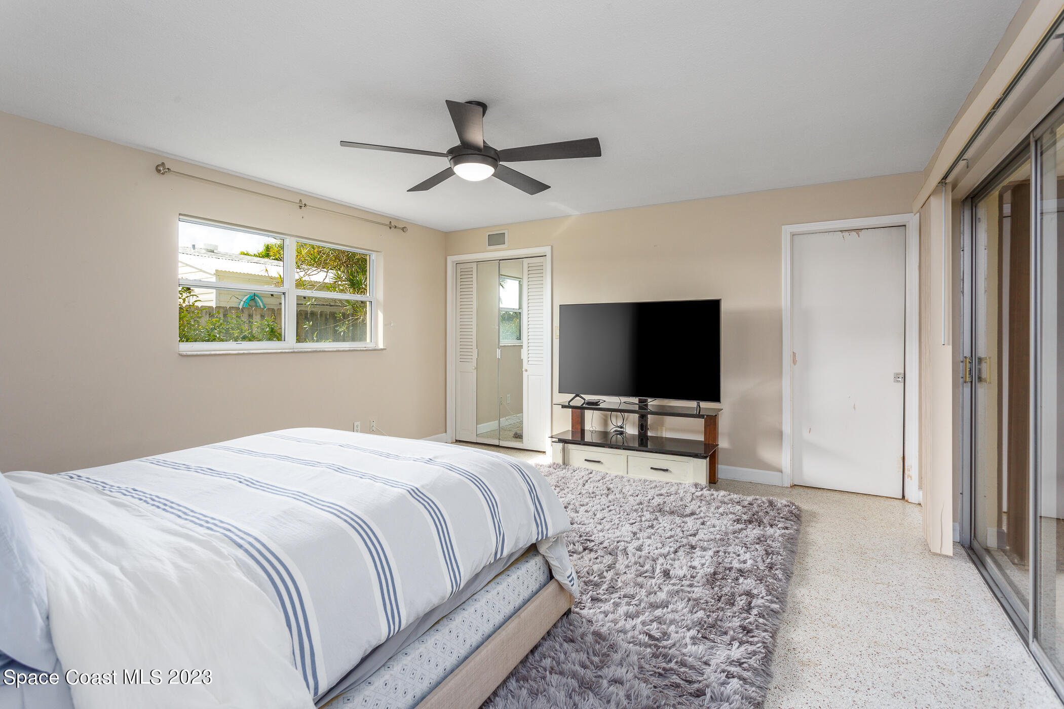 608 Mango Drive Melbourne Beach, FL 32951 - Photo 12 of 30 a bedroom with a bed and a flat screen tv