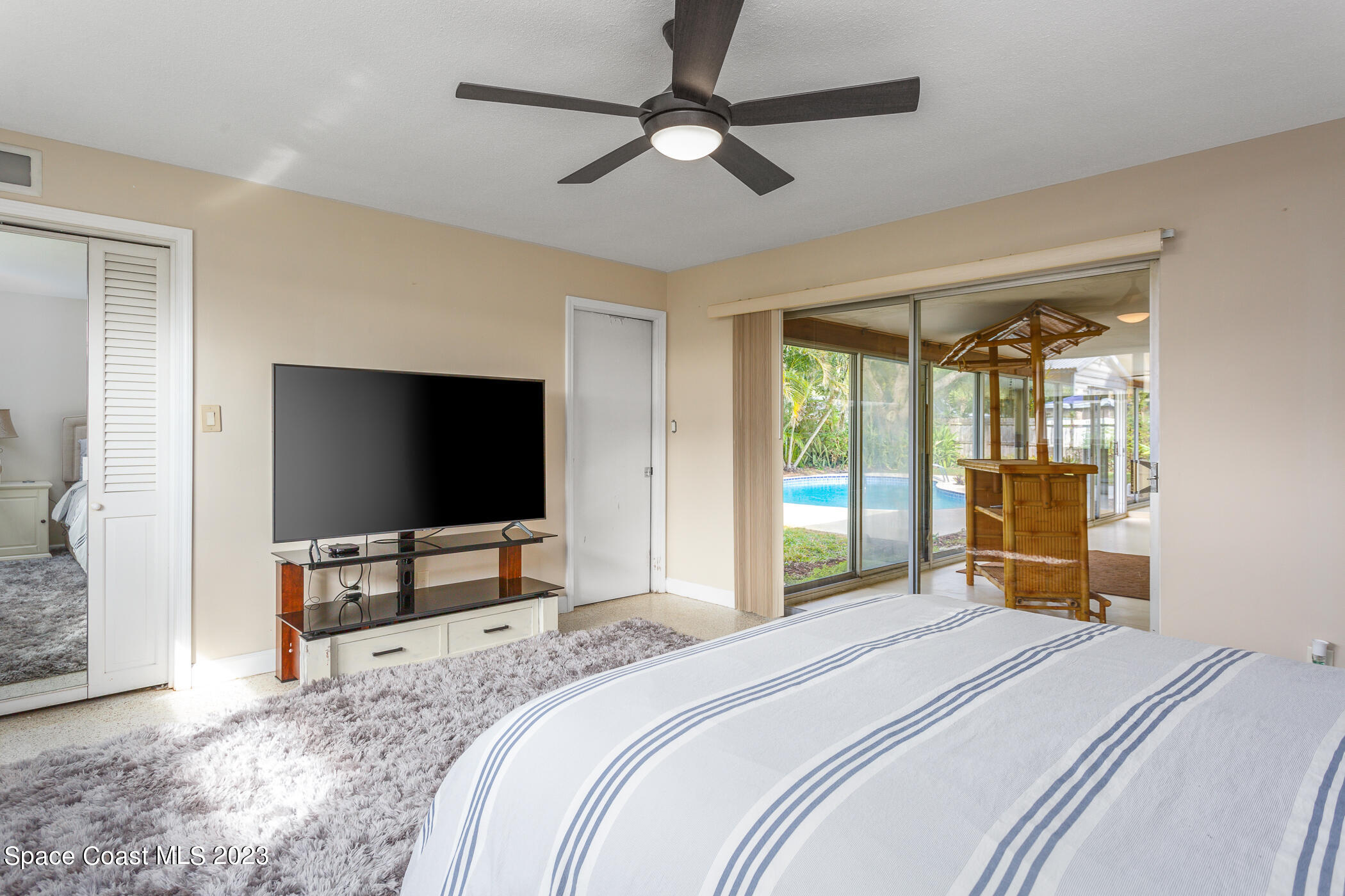 608 Mango Drive Melbourne Beach, FL 32951 - Photo 13 of 30 a bedroom with a bed and a flat screen tv