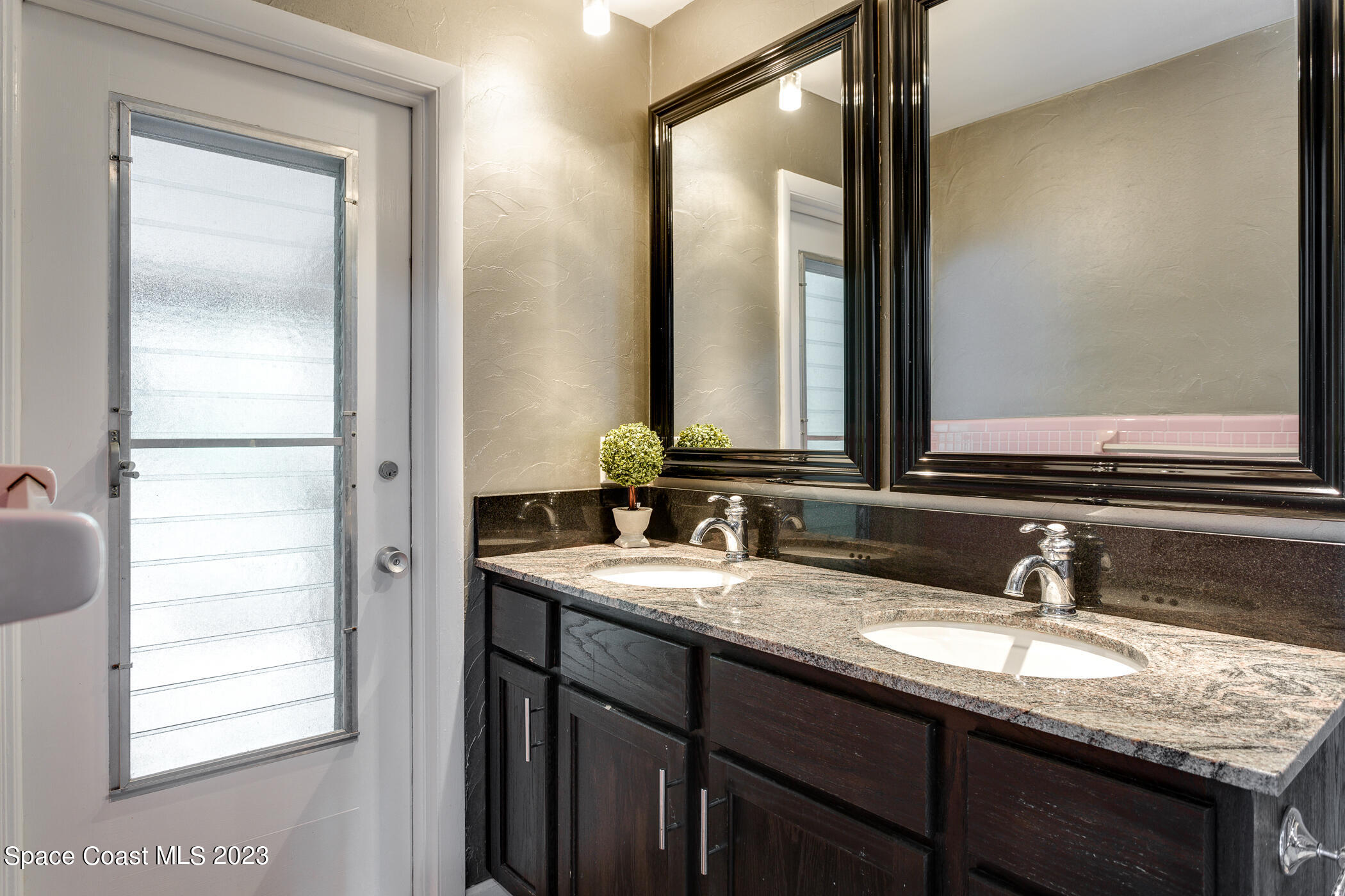 608 Mango Drive Melbourne Beach, FL 32951 - Photo 18 of 30 a bathroom with a granite countertop sink and a mirror