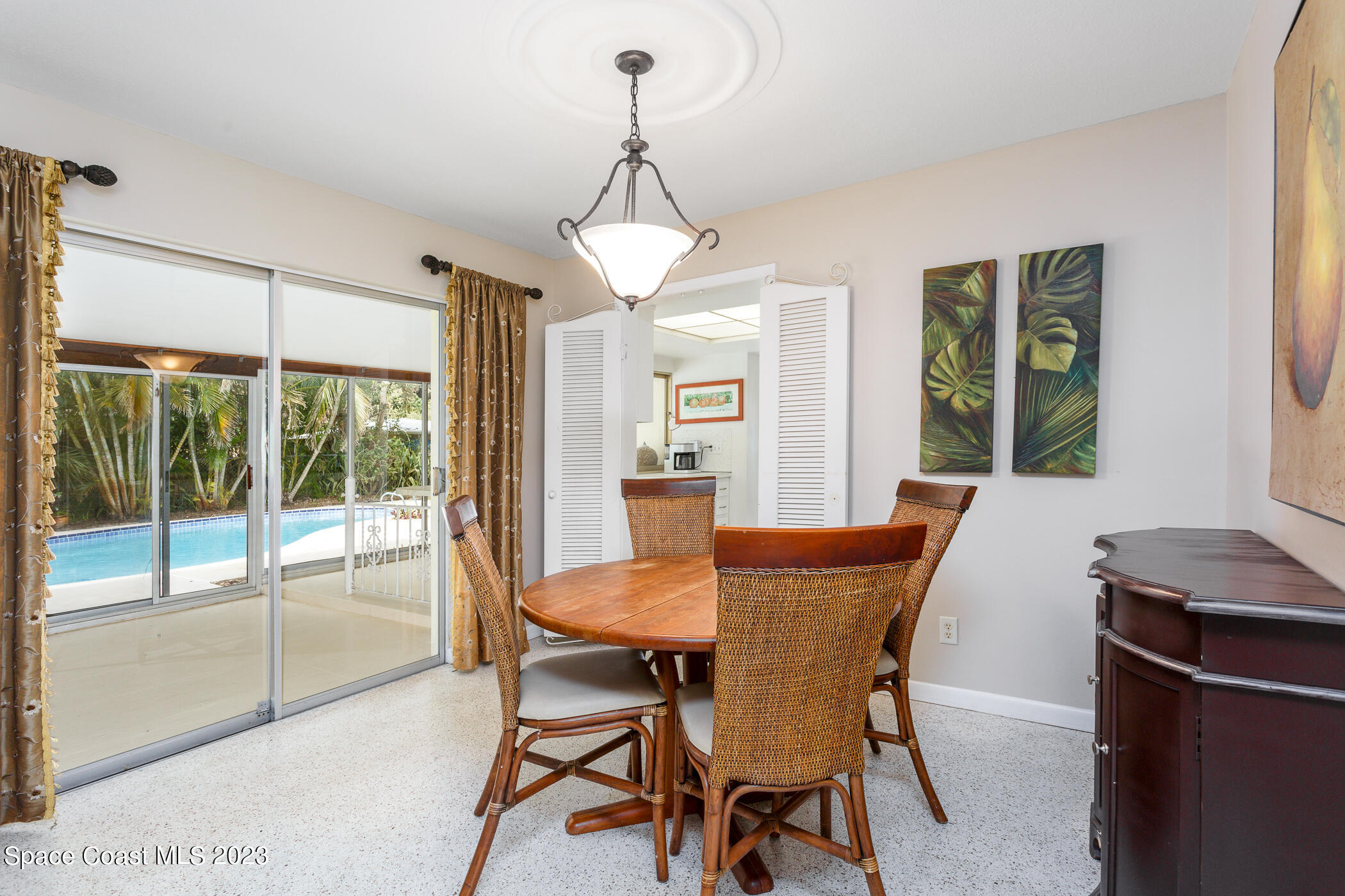 608 Mango Drive Melbourne Beach, FL 32951 - Photo 4 of 30 a dining room with furniture a chandelier and wooden floor