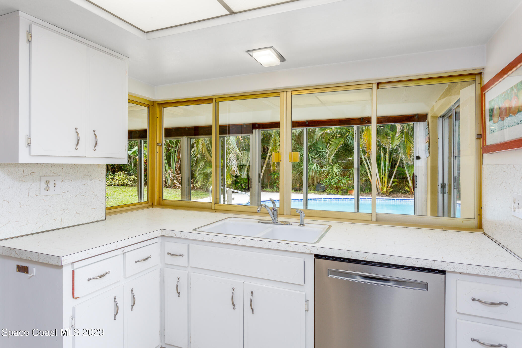 608 Mango Drive Melbourne Beach, FL 32951 - Photo 6 of 30 a view of a kitchen with a sink and large window