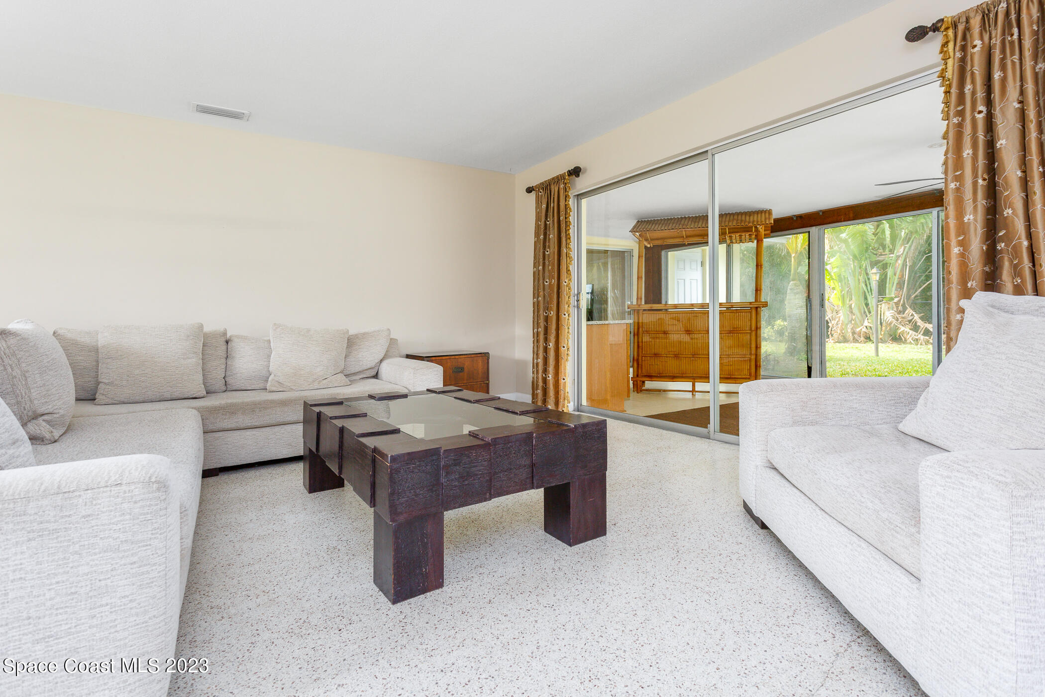 608 Mango Drive Melbourne Beach, FL 32951 - Photo 8 of 30 a living room with furniture and large windows