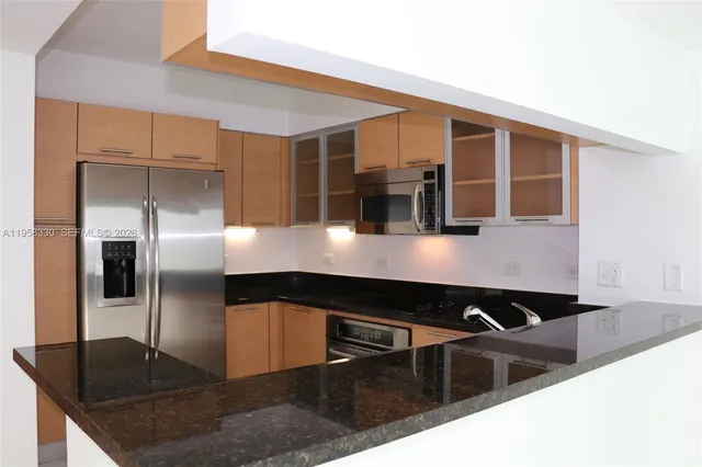 a kitchen with kitchen island a refrigerator and a counter top