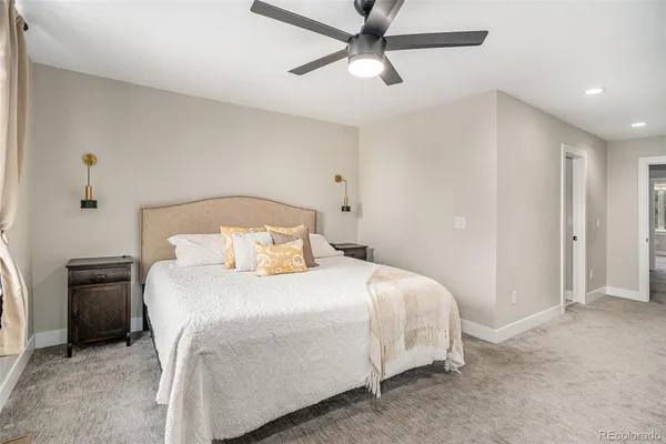 a bedroom with a bed and a ceiling fan