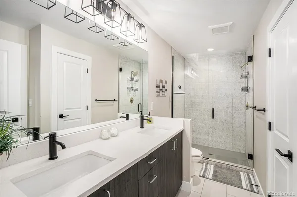 a bathroom with a double vanity sink mirror double and shower