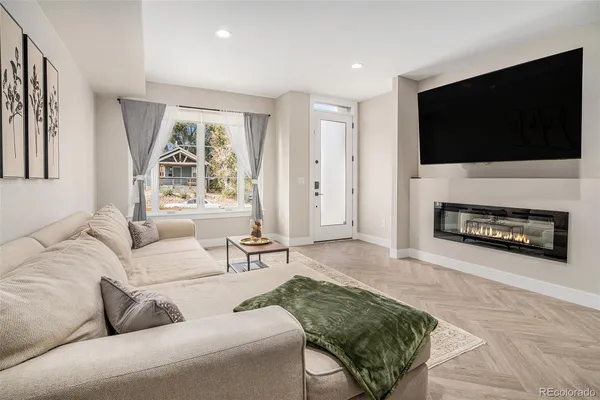 a living room with furniture a flat screen tv and a fireplace
