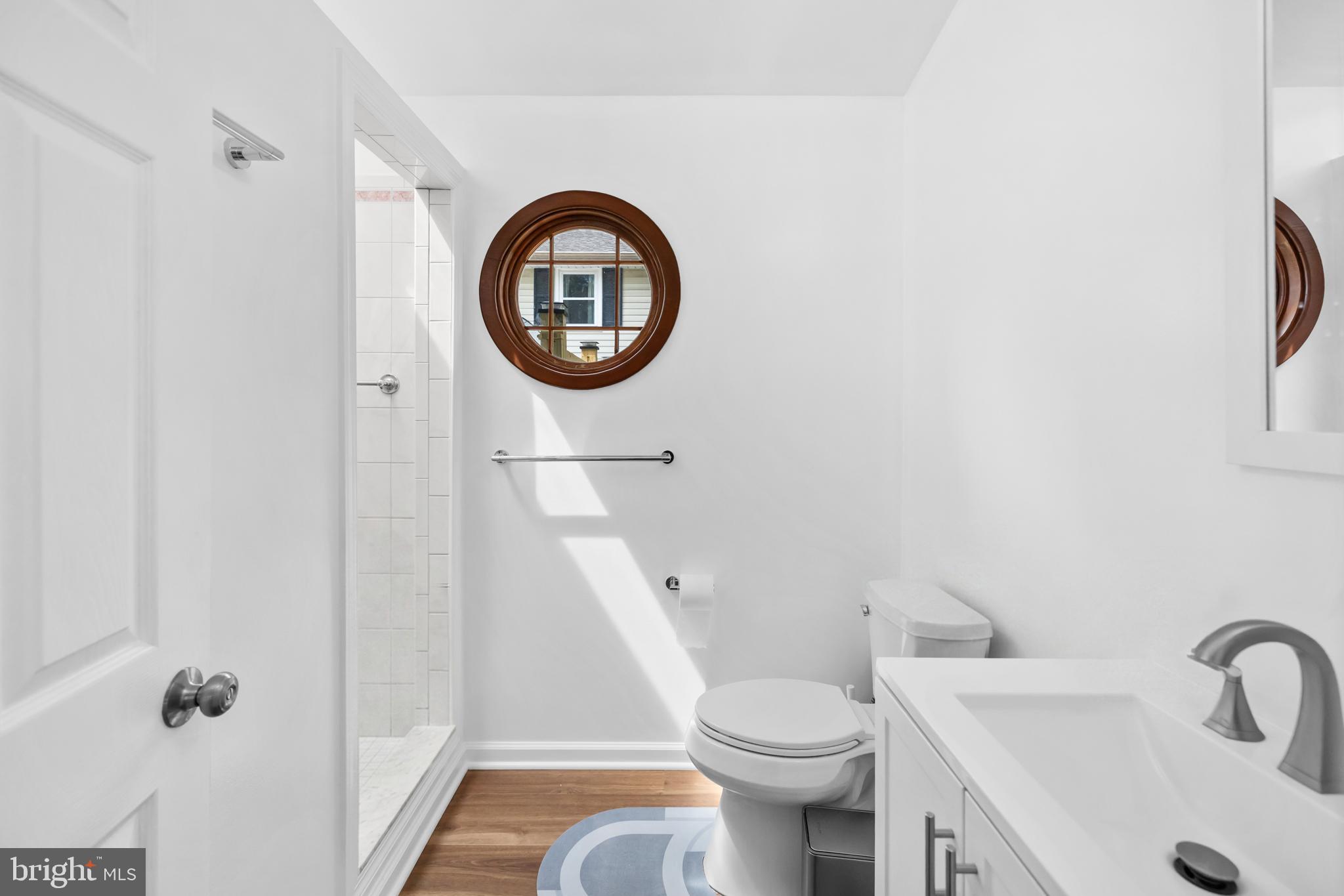 7402 Dunston Street Springfield, VA 22151 - Photo 18 of 37 a bathroom with a toilet a sink and a mirror