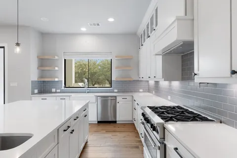a kitchen with a sink stove top oven and cabinets