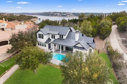 an aerial view of residential houses with outdoor space and river