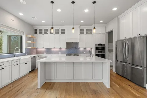 a kitchen with stainless steel appliances granite countertop a sink stove and refrigerator