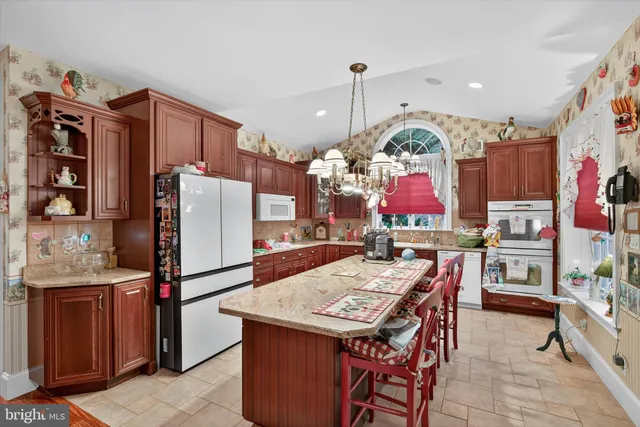 a living room with furniture a flat screen tv and kitchen view