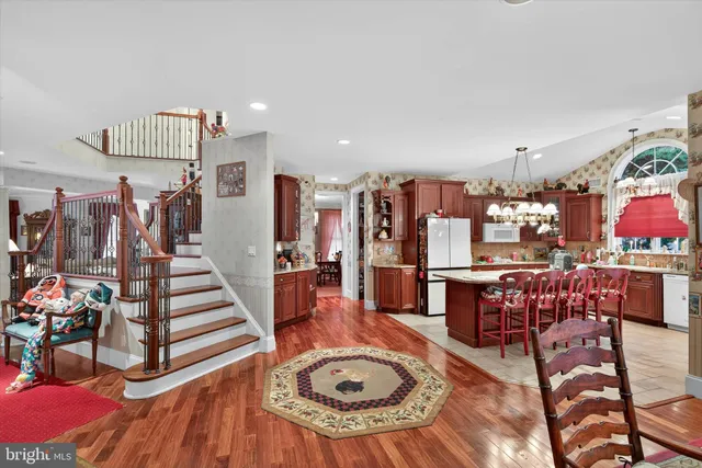 a kitchen with stainless steel appliances granite countertop a sink a stove and a wooden floors