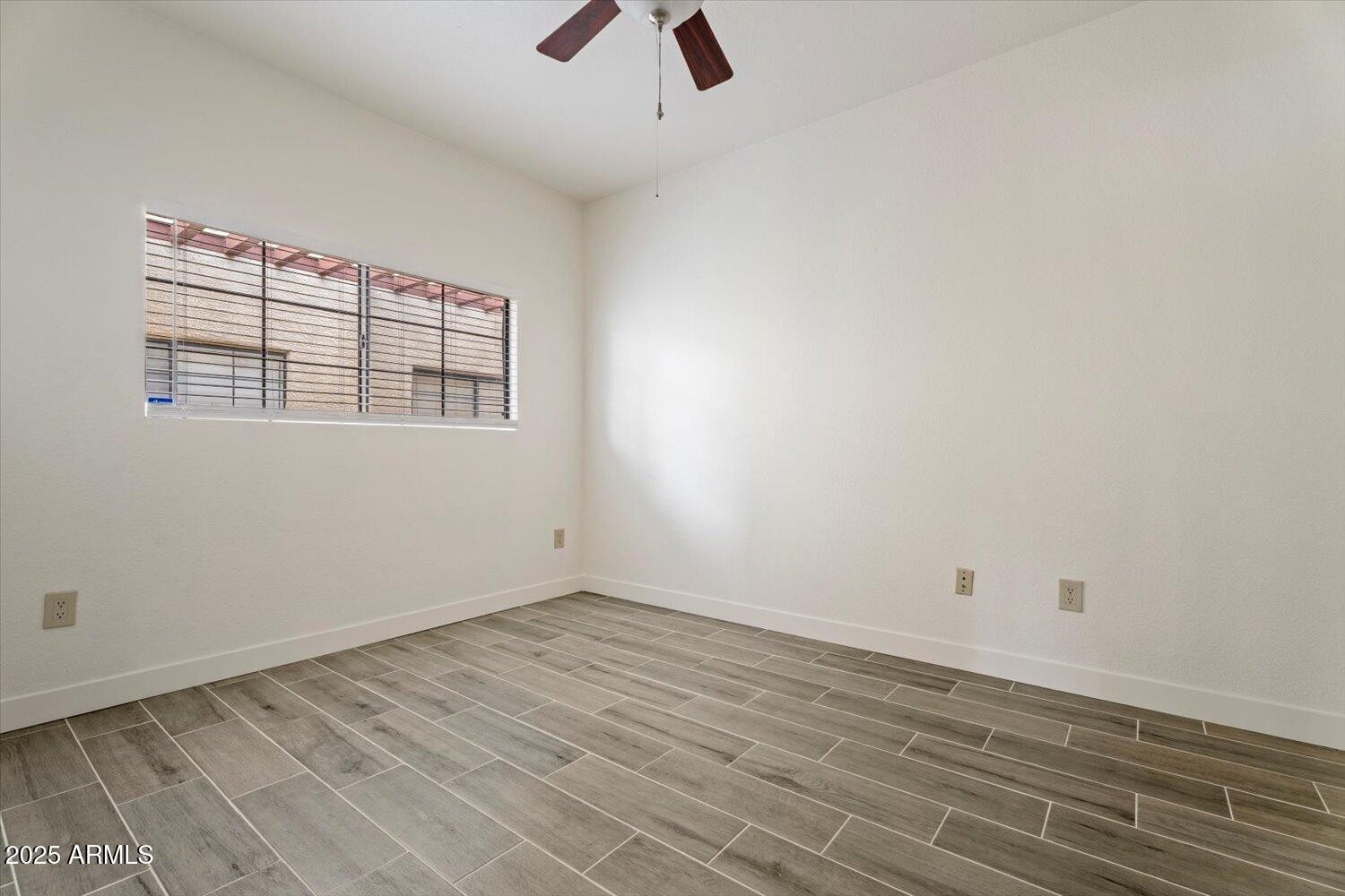 3434 East Baseline Road, Unit 260 Phoenix, AZ 85042 - Photo 12 of 15 an empty room with wooden floor and windows