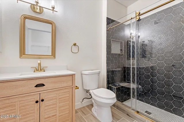 a bathroom with a toilet sink vanity and mirror