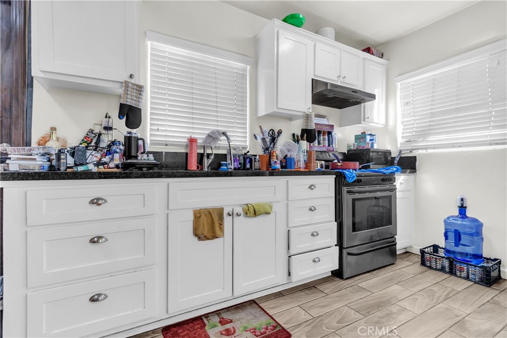 141 West 83rd Street Los Angeles, CA 90003 - Photo 13 of 22 a kitchen with white cabinets and white appliances