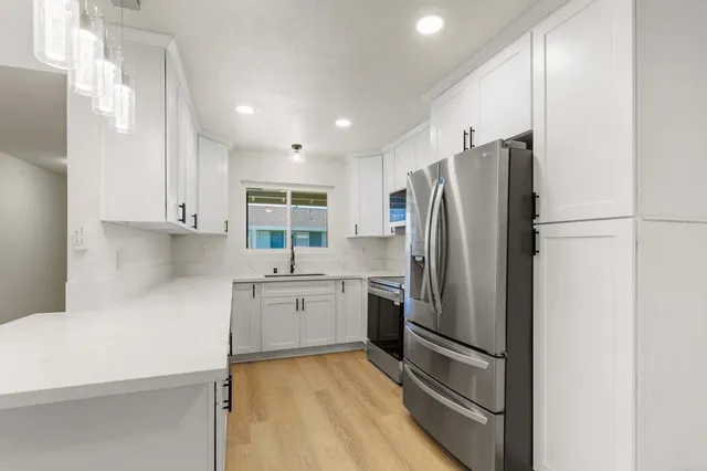 a kitchen with a refrigerator a sink and cabinets