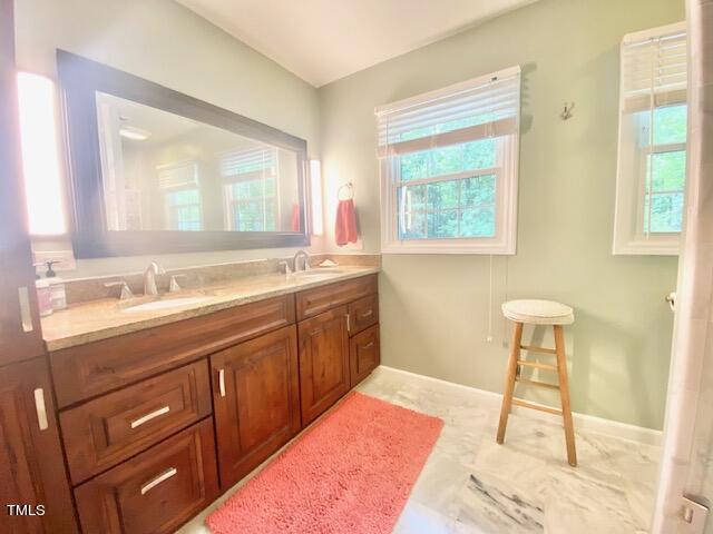 4400 Currie Court Raleigh, NC 27613 - Photo 22 of 35 a spacious bathroom with a sink and a mirror