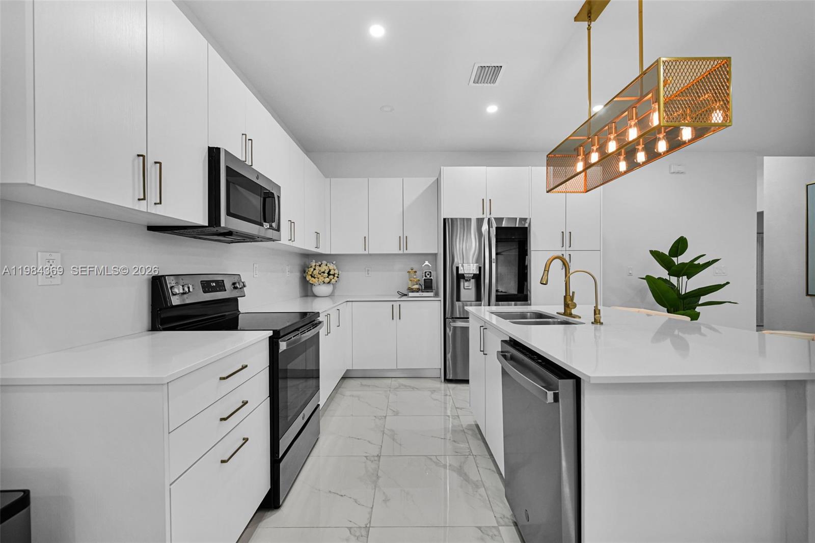 13334 Southwest 227th Street Miami, FL 33170 - Photo 40 of 69 a kitchen with stainless steel appliances white cabinets a sink a stove a refrigerator and a window