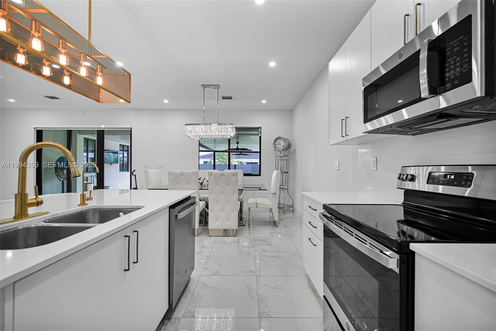 13334 Southwest 227th Street Miami, FL 33170 - Photo 42 of 69 a kitchen with stainless steel appliances granite countertop a sink and stove top oven with wooden floor