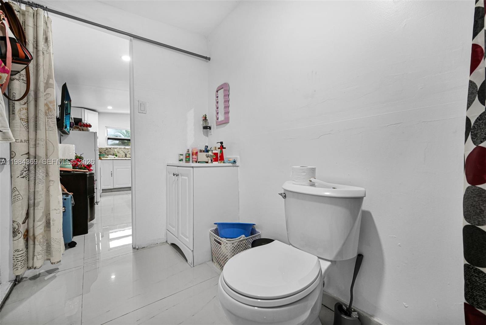 13334 Southwest 227th Street Miami, FL 33170 - Photo 46 of 69 a white toilet sitting next to a bathroom sink and vanity