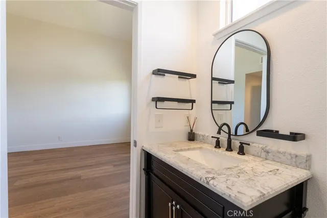 a bathroom with a granite countertop sink and a mirror