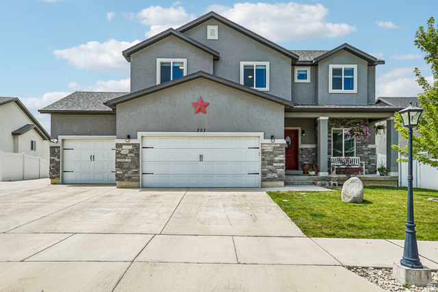 203 North 1900th Street West Mapleton, UT 84664 - Photo 1 of 48 Contemporary stucco exterior with a stone accent facade, featuring a red entry door and a covered front porch