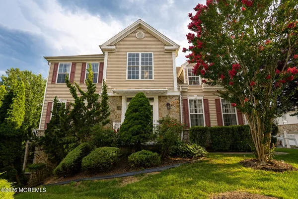 a front view of a house with a yard and trees