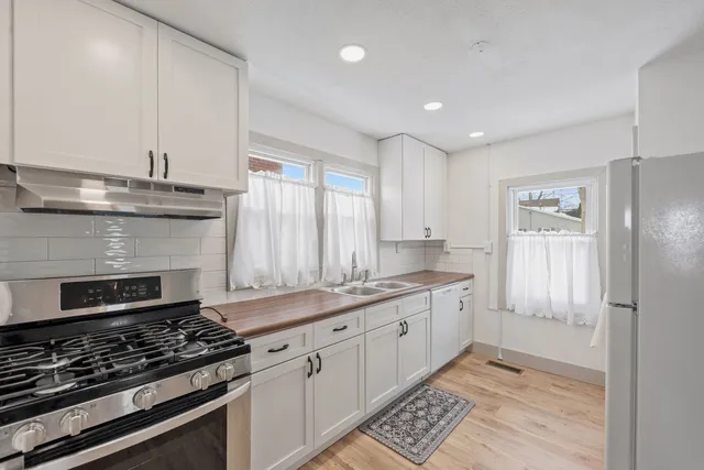 a kitchen with granite countertop stainless steel appliances sink and cabinets